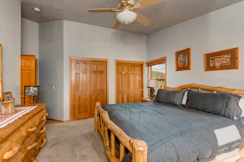 A rustic log-frame King bed, ceiling fan, and double closets for extended stays.