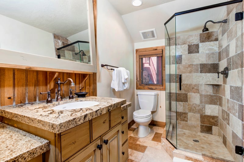 The ensuite bath features a granite vanity, walk-in shower, and wood cabinetry.