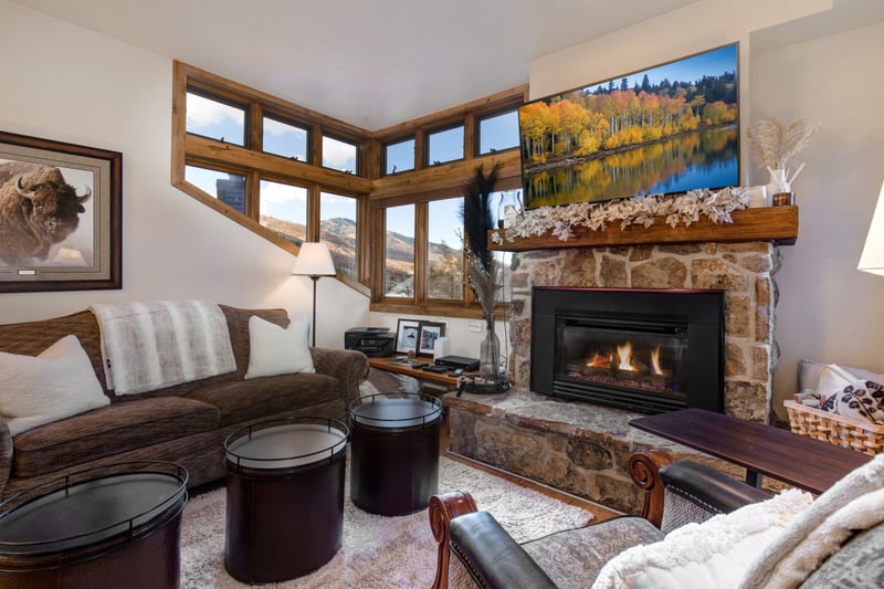 Cozy mountain living room with fireplace, rustic charm, and warmth.