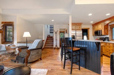 The fully equipped kitchen features granite counters, bar seating, and full-size appliances.