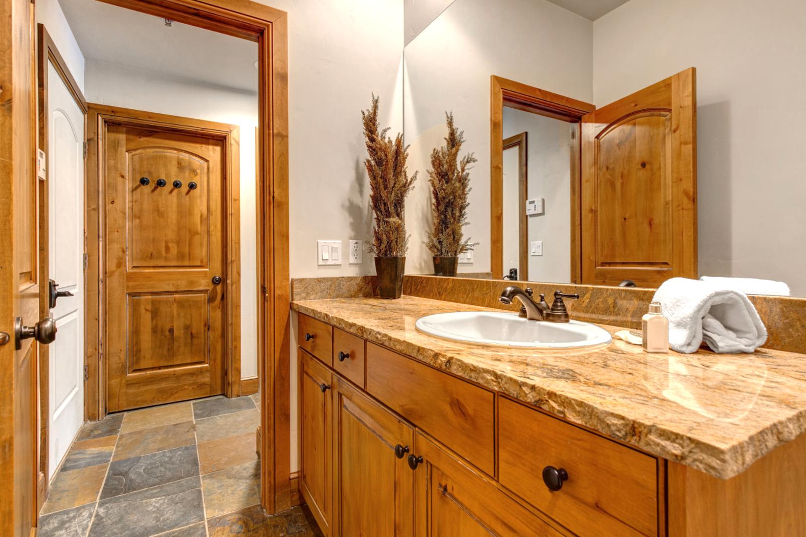 Main-level powder room includes a granite vanity and lodge-inspired wood details.