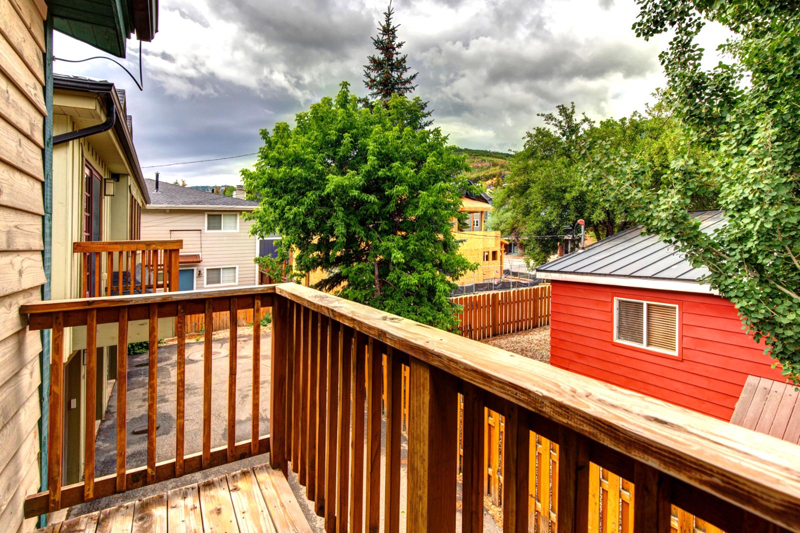 Wood deck balcony right off of bedroom suite offers space to sip morning coffee or enjoy evening views.