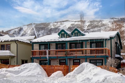 Charming duplex framed by fresh snow, wooden balconies, and a scenic mountain backdrop. PPS-1416