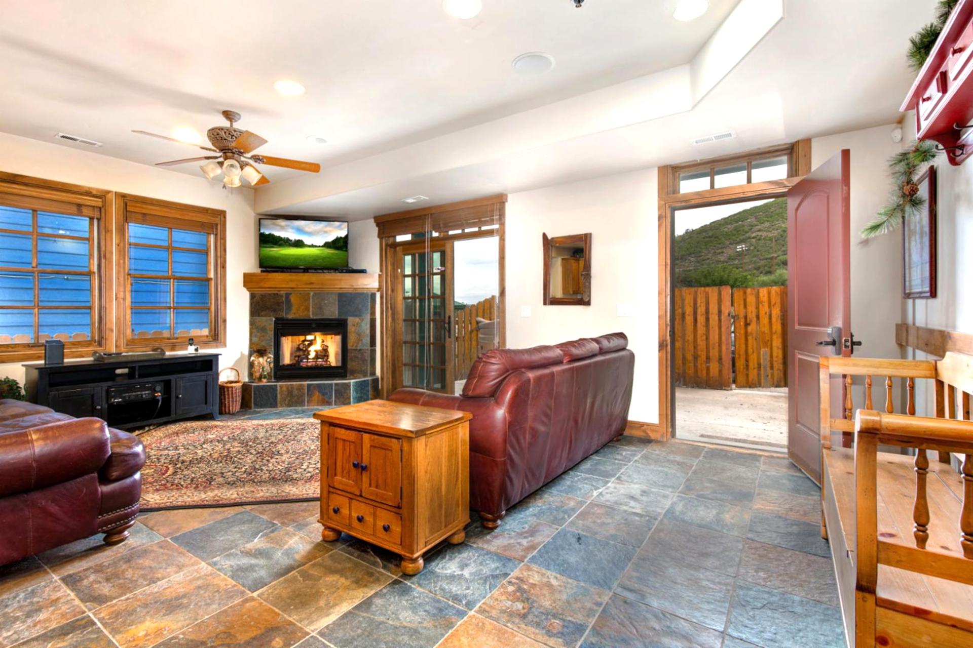 Your spacious entry opens into the main living area, with natural slate floors and warm wood finishes throughout.
