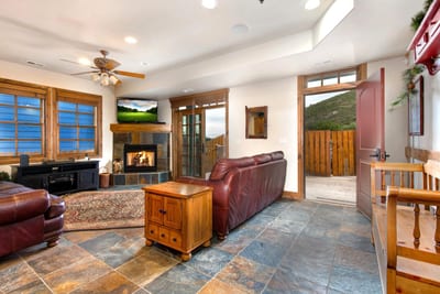 Your spacious entry opens into the main living area, with natural slate floors and warm wood finishes throughout.
