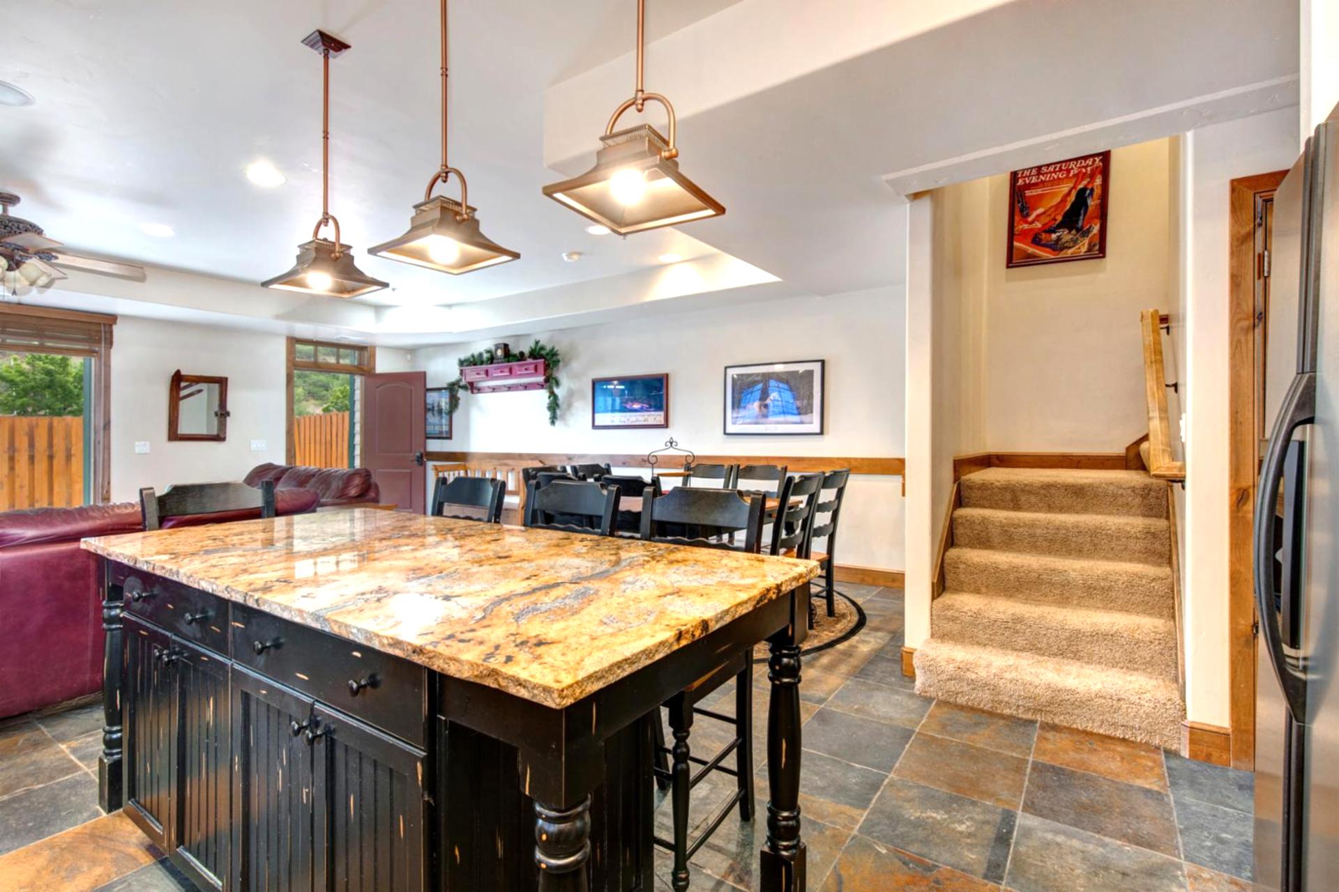 A second angle of the kitchen highlights the bar seating and view toward the living room and stairs.
