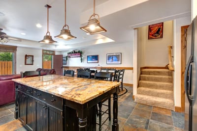 A second angle of the kitchen highlights the bar seating and view toward the living room and stairs.