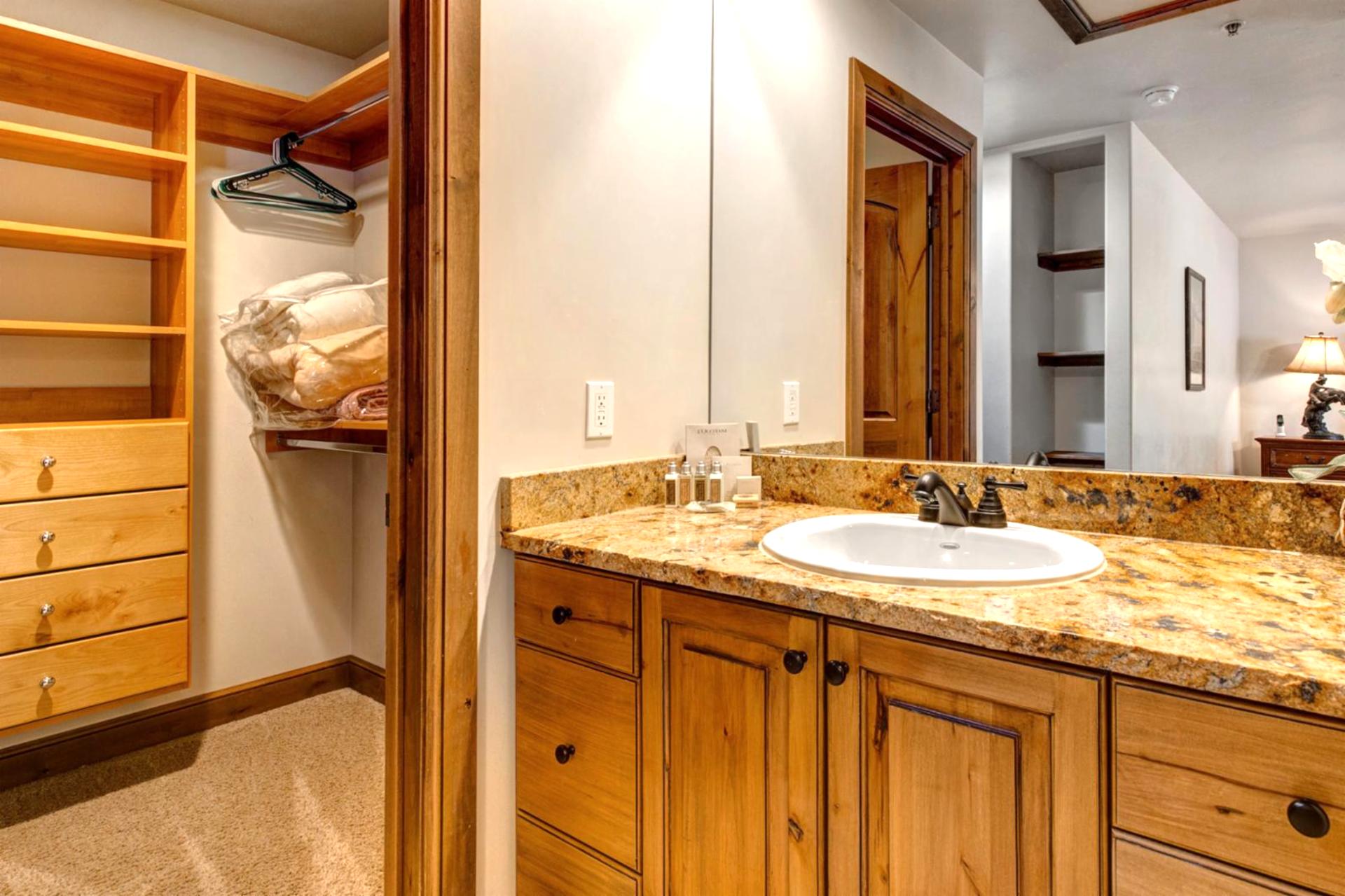 The primary ensuite offers dual granite vanities, warm wood cabinetry, and plenty of space to refresh.
