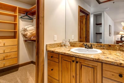 The primary ensuite offers dual granite vanities, warm wood cabinetry, and plenty of space to refresh.