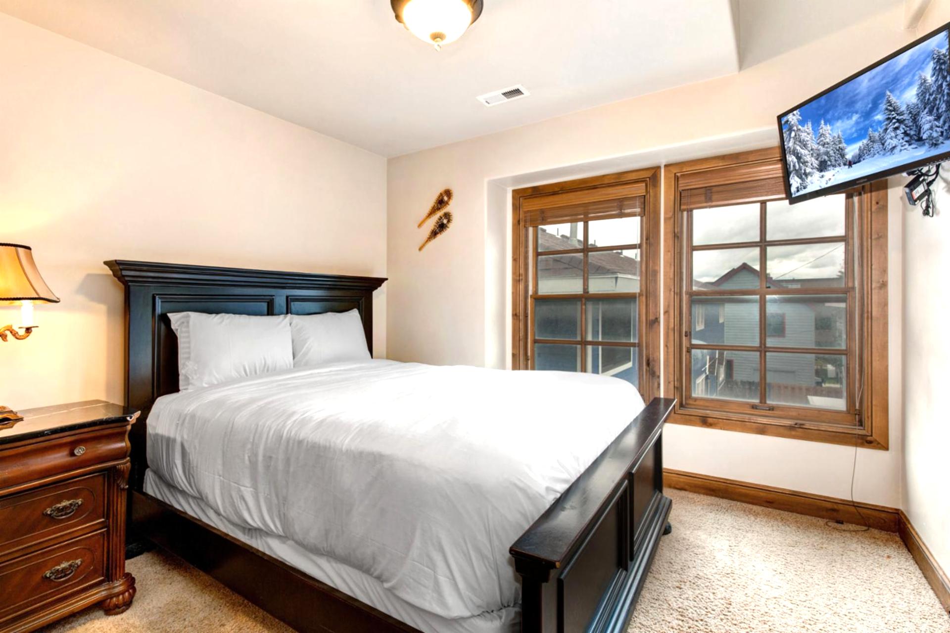 Guest Bedroom 1 features a Queen bed, Smart TV, and private balcony access for fresh mountain air.

