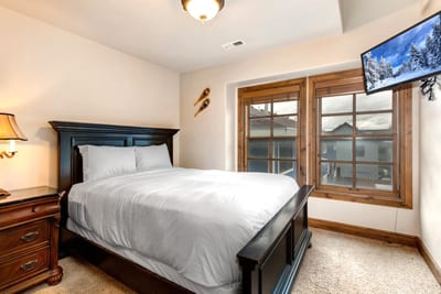 Guest Bedroom 1 features a Queen bed, Smart TV, and private balcony access for fresh mountain air.