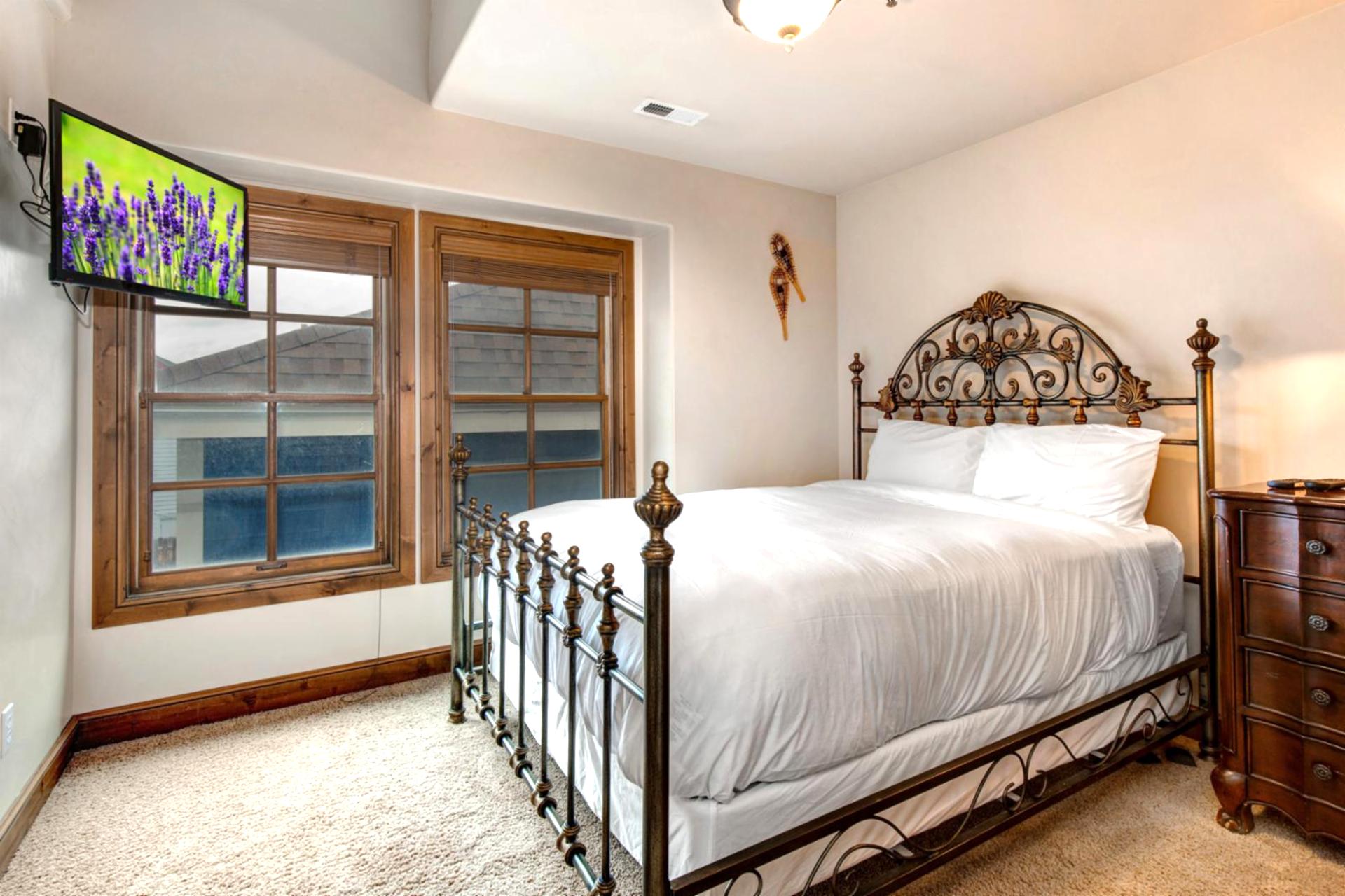 Guest Bedroom 2 includes a Queen bed, dresser, and double windows with wood shutters.
