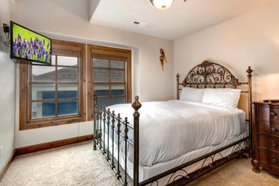 Guest Bedroom 2 includes a Queen bed, dresser, and double windows with wood shutters.