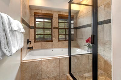 Indulge in a soak after a day outdoors in your spa-style bath with glass walk-in shower and deep tub.