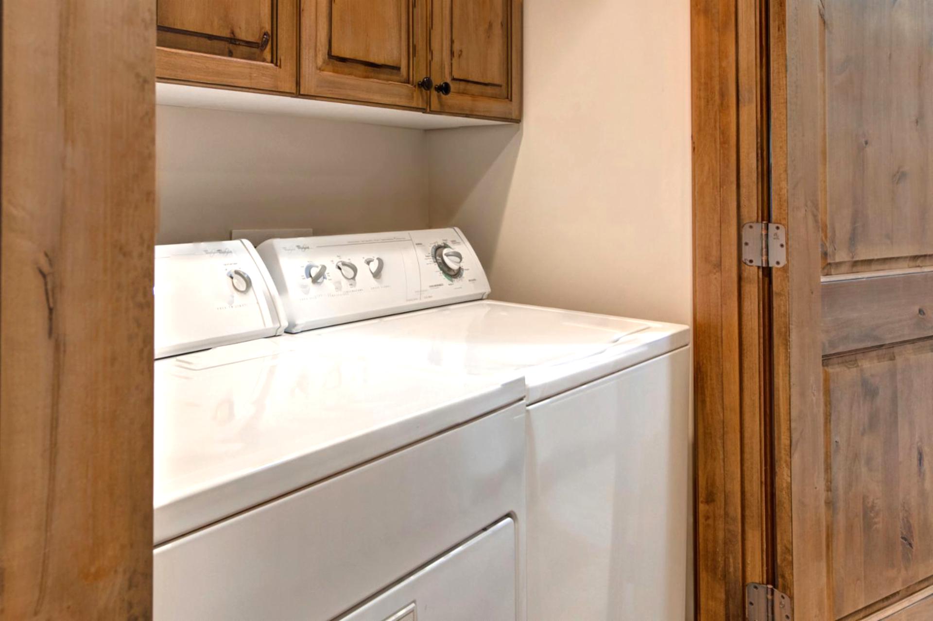 Full laundry room with washer, dryer, and ample storage to keep gear organized.
