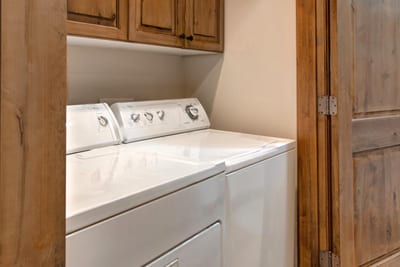 Full laundry room with washer, dryer, and ample storage to keep gear organized.