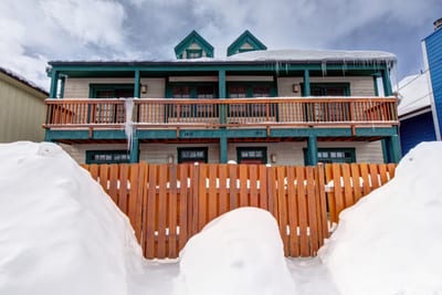 A snow-covered view of your townhome entry, just steps from adventure with two private balconies above.