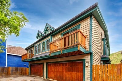 The townhome’s front-facing exterior with garage and private balconies above.