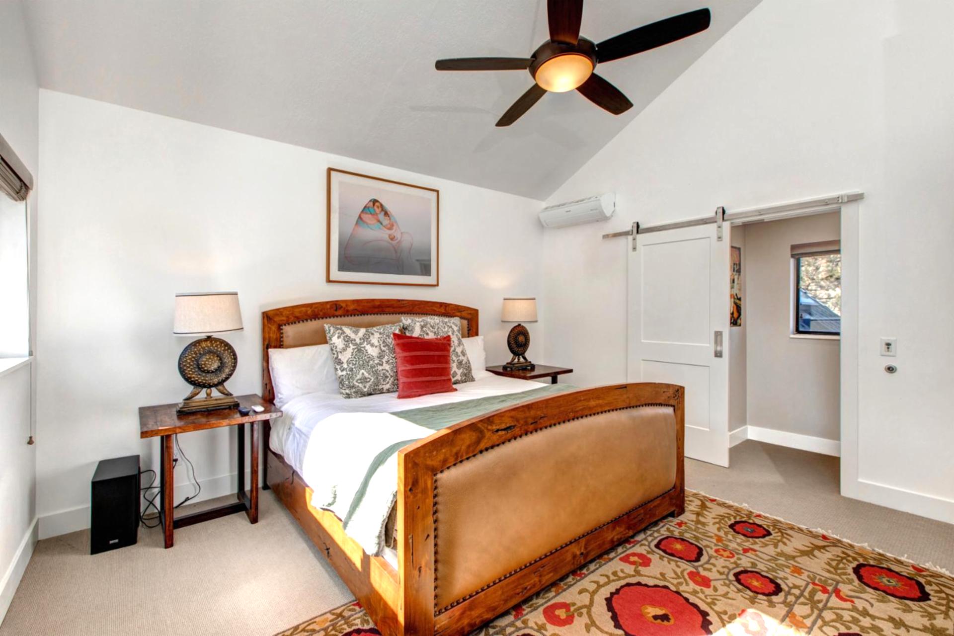 Located on the upper level, the primary suite includes a King bed, ceiling fan, and private en suite bath.