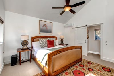 Located on the upper level, the primary suite includes a King bed, ceiling fan, and private en suite bath.