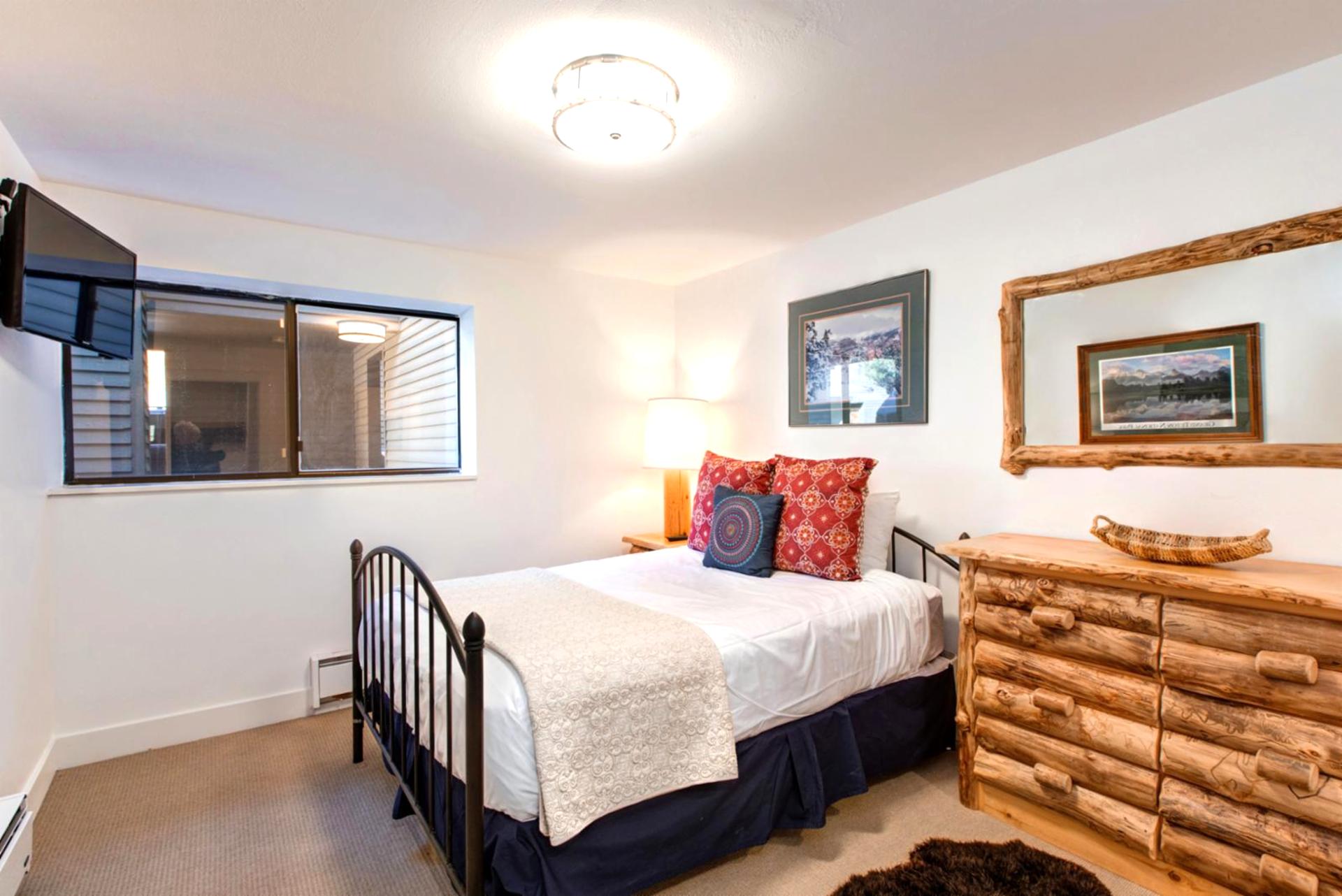 Main-level bunk room features a Full-over-Full log frame bed, cozy lighting, and mountain-inspired decor.