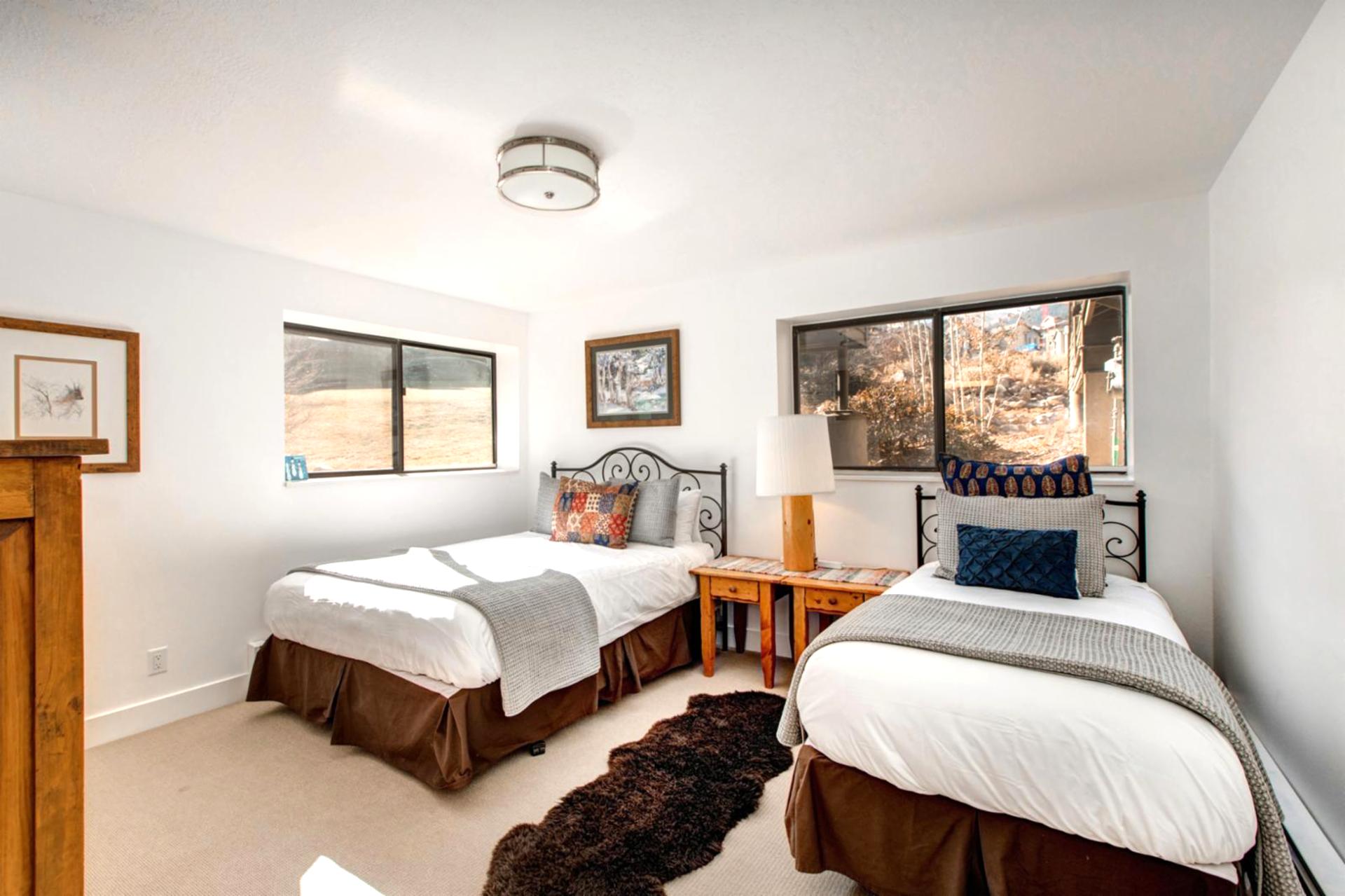 A Queen bed, plush carpet, and large window create a restful lower-level bedroom retreat.