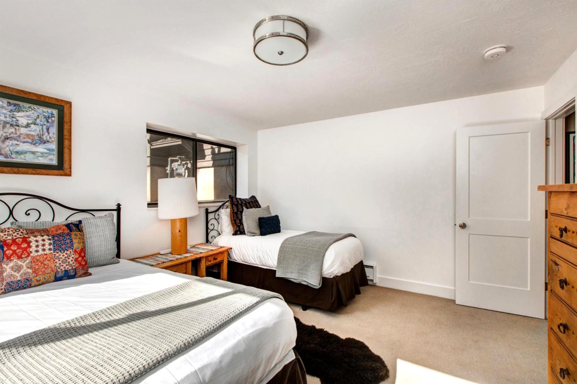 Alternate view of the lower-level Queen bedroom shows generous space and classic alpine furnishings.