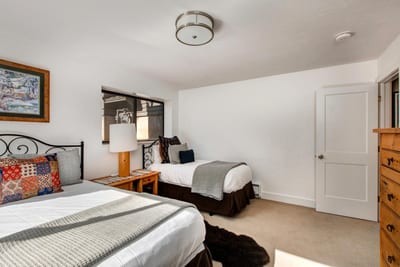 Alternate view of the lower-level Queen bedroom shows generous space and classic alpine furnishings.