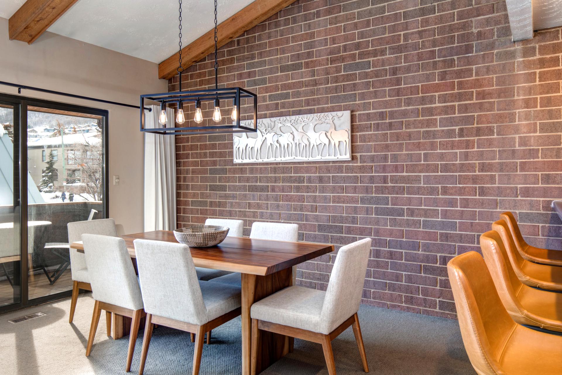 Share meals or board games at your dining table for six beneath modern lighting and brick walls.