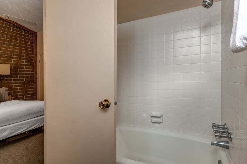 Clean and functional, this full bath serves Bedroom 1 with a shower/tub combo.