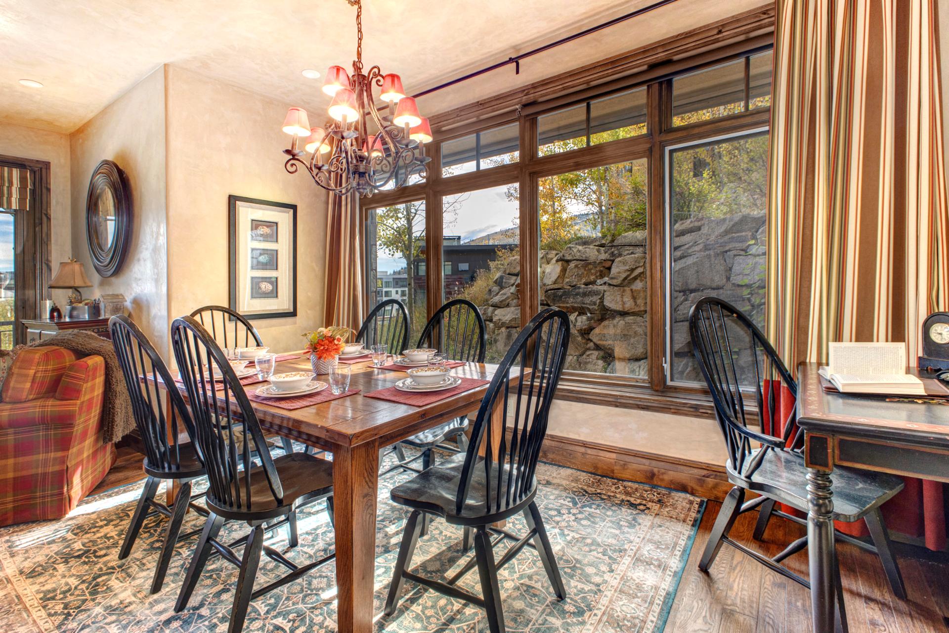 Gather at the elegant dining table with forest views and soft lighting for après-ski dinners or game night.