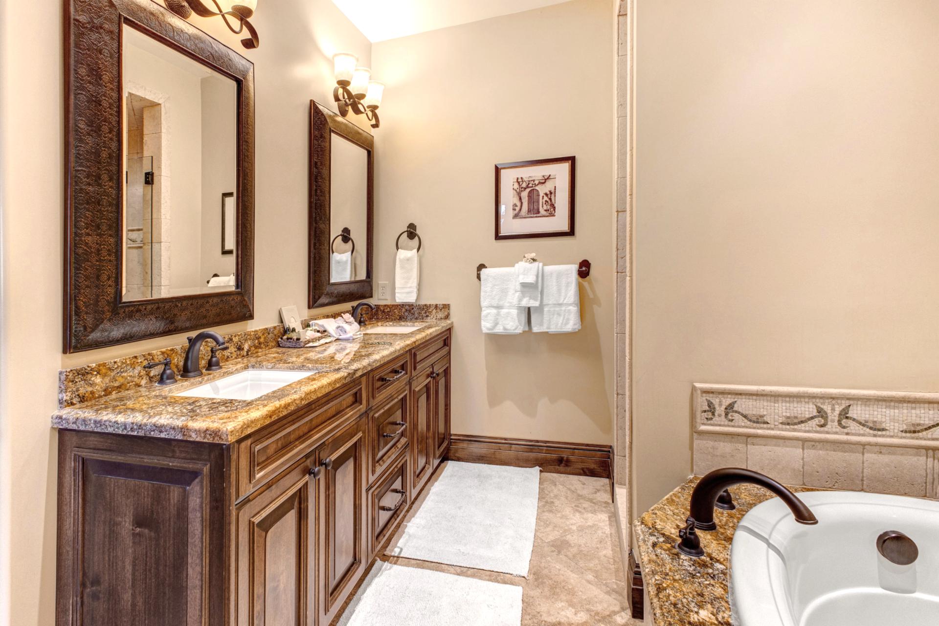 The spacious primary bath includes a double vanity, walk-in shower, and natural wood finishes.