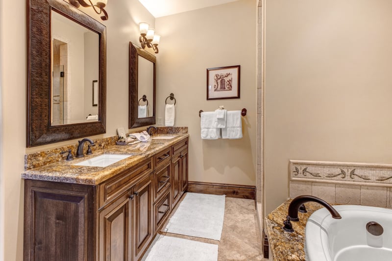The spacious primary bath includes a double vanity, walk-in shower, and natural wood finishes.