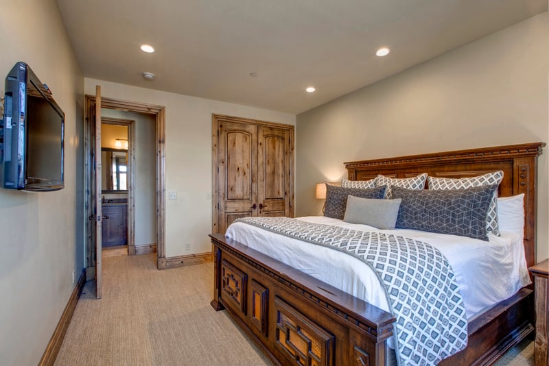 Spacious rustic bedroom with plush bedding and handcrafted wooden furniture charm.