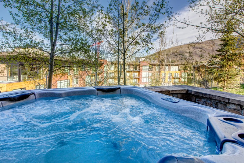 Bubbling hot tub with scenic mountain views and lush greenery.