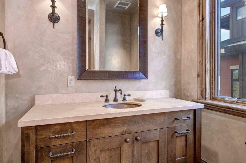 Rustic bathroom vanity with elegant lighting and warm wood accents.