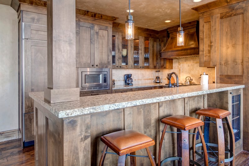 Warm wood cabinetry, pendant lighting, and stainless steel finishes bring style and function to the kitchen.